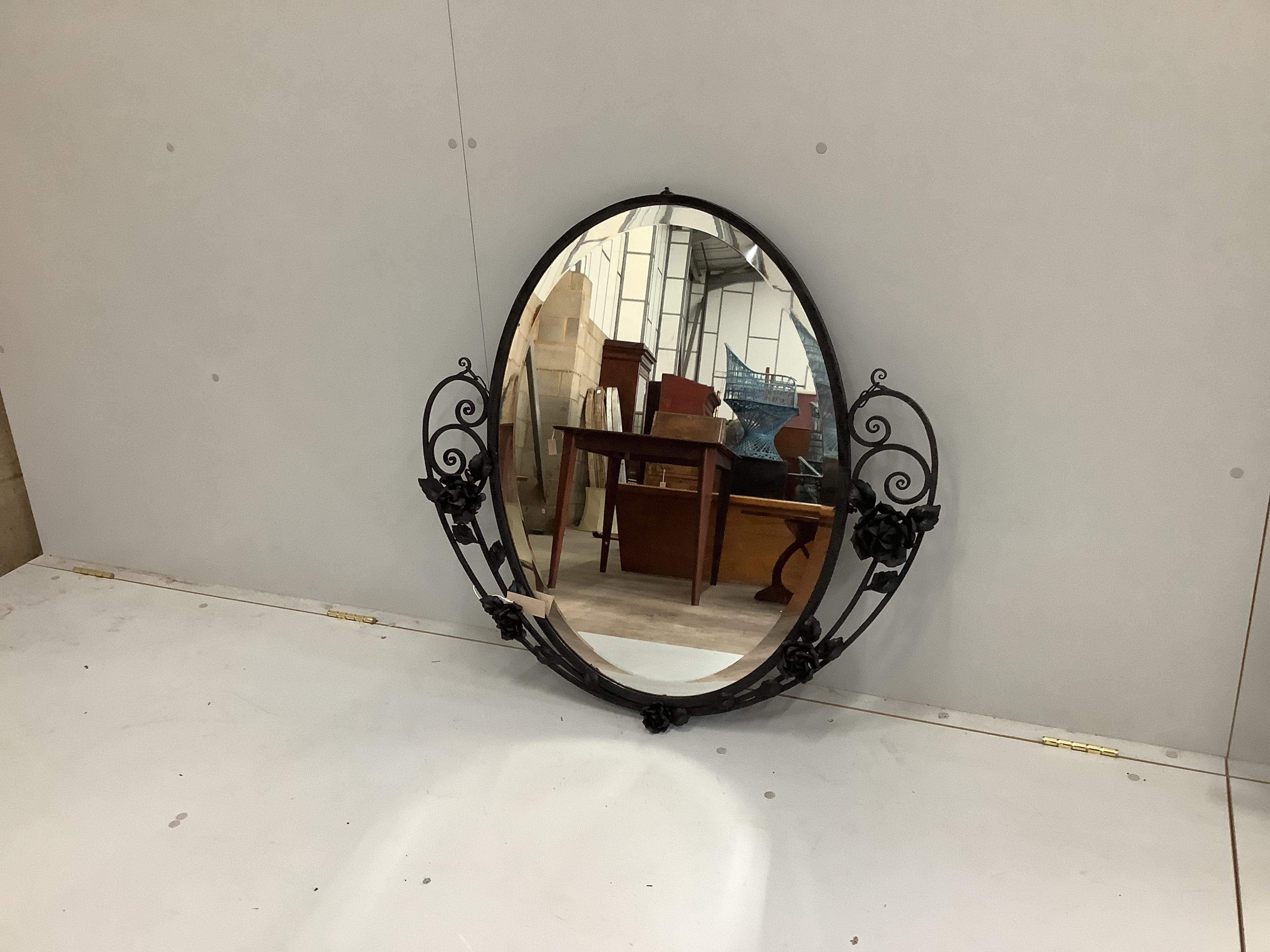An early 20th century French wrought iron oval wall mirror, width 87cm, height 86cm